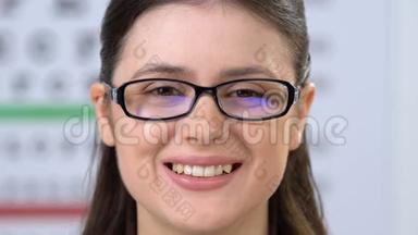 戴眼镜的女人对着镜头微笑，眼科问题的治疗